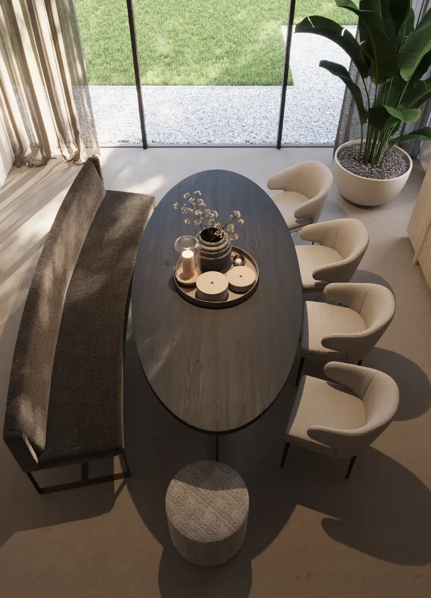 Een moderne eethoek met een ovale donkerhouten tafel, vier licht gestoffeerde stoelen, een donkere bank, een kleine ronde kruk, een grote potplant en ramen van vloer tot plafond die een groen gazon buiten tonen.