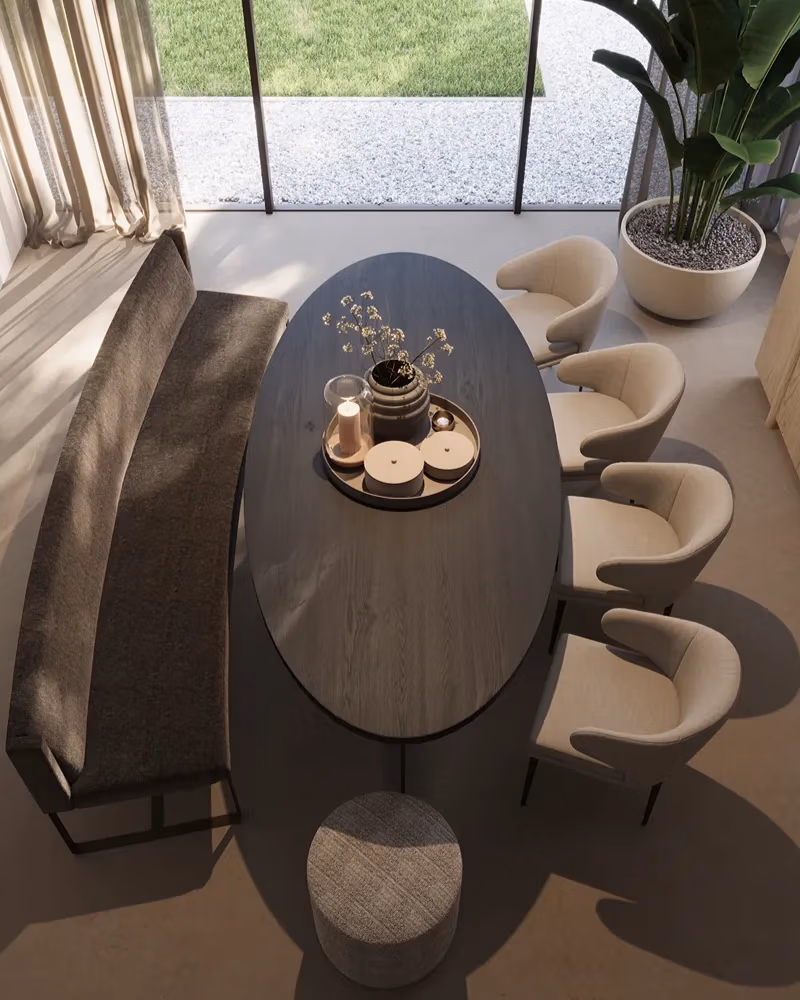 Een moderne eethoek die naadloos is ontworpen voor wie zijn woonkamer wil vernieuwen, met een ovale donkere tafel, vier beige fauteuils, een grijze bank en een ronde poef. Decoratieve dienbladen en vazen zorgen voor extra stijl op de tafel, terwijl grote ramen het uitzicht op een groen gazon en een nabijgelegen potplant omlijsten.